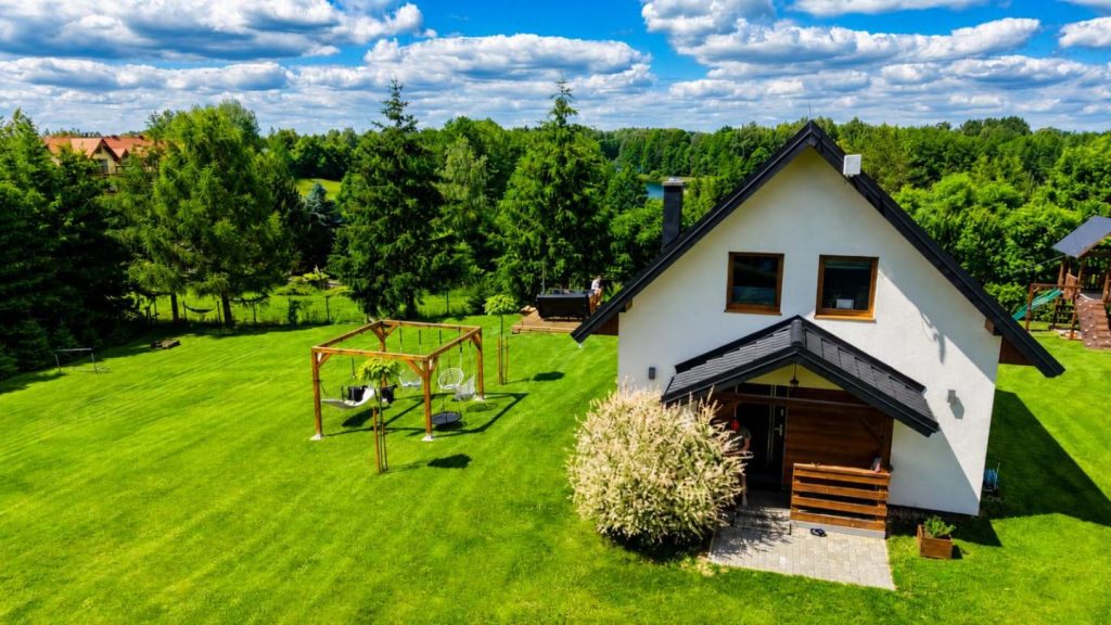 Domek z kominkiem nad jeziorem z jacuzzi ogrodowym